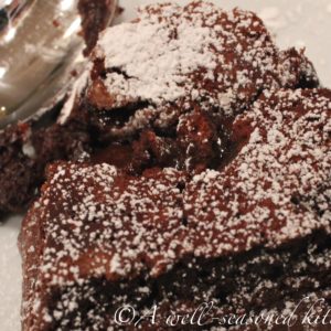 close up of a heart shaped mini chocolate cake, cut into on top to show melty filling.
