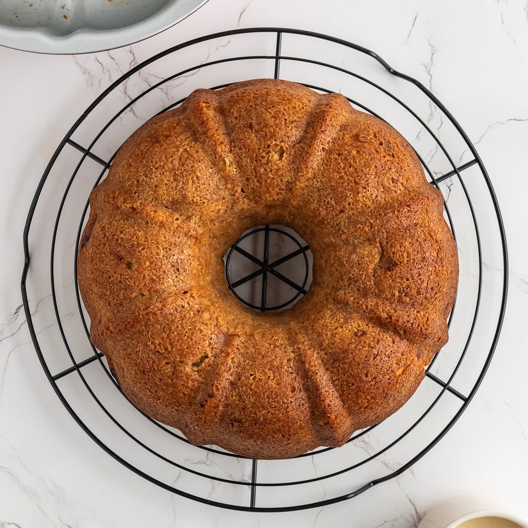 Baked apple bundt cake flipped onto a wire rack to cool.