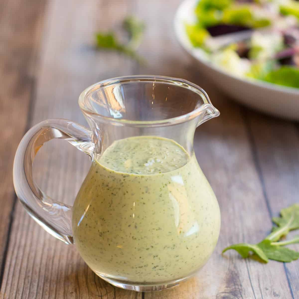 Carafe of creamy arugula salad dressing