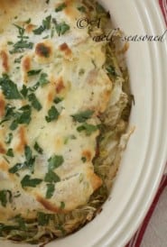Baked fish on shredded lettuce topped with mayonnaise, Parmesan cheese and parsley