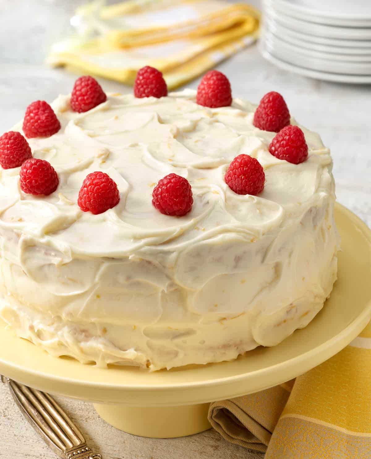 Banana Raspberry Cake with Lemon Frosting on a cake stand