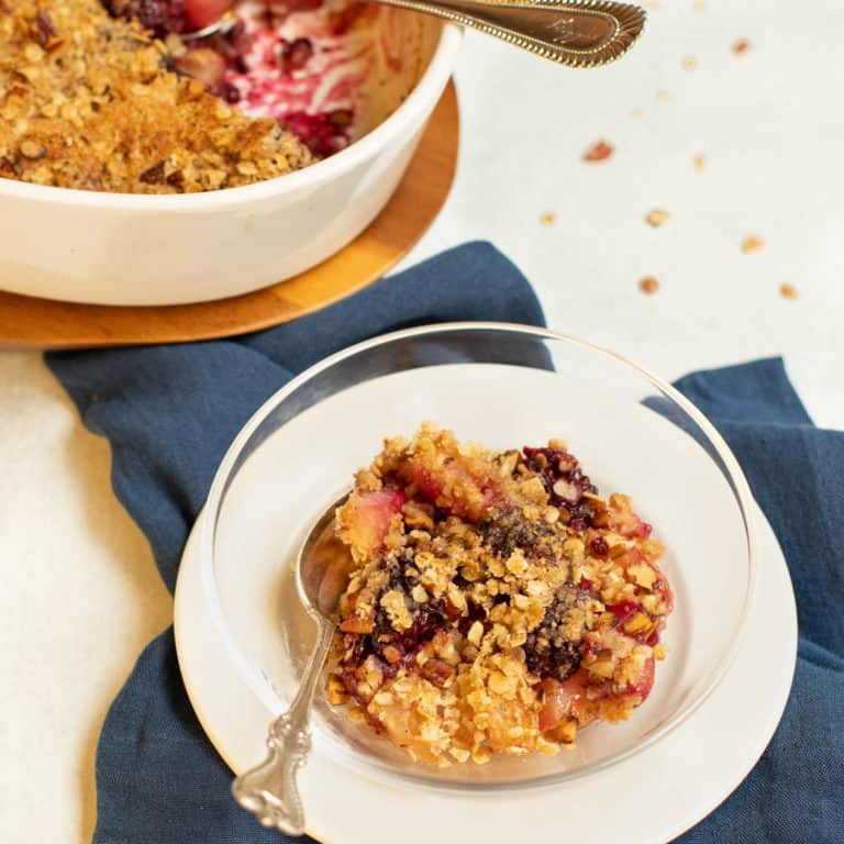 single serving of Blackberry Pear Crisp with full baking dish