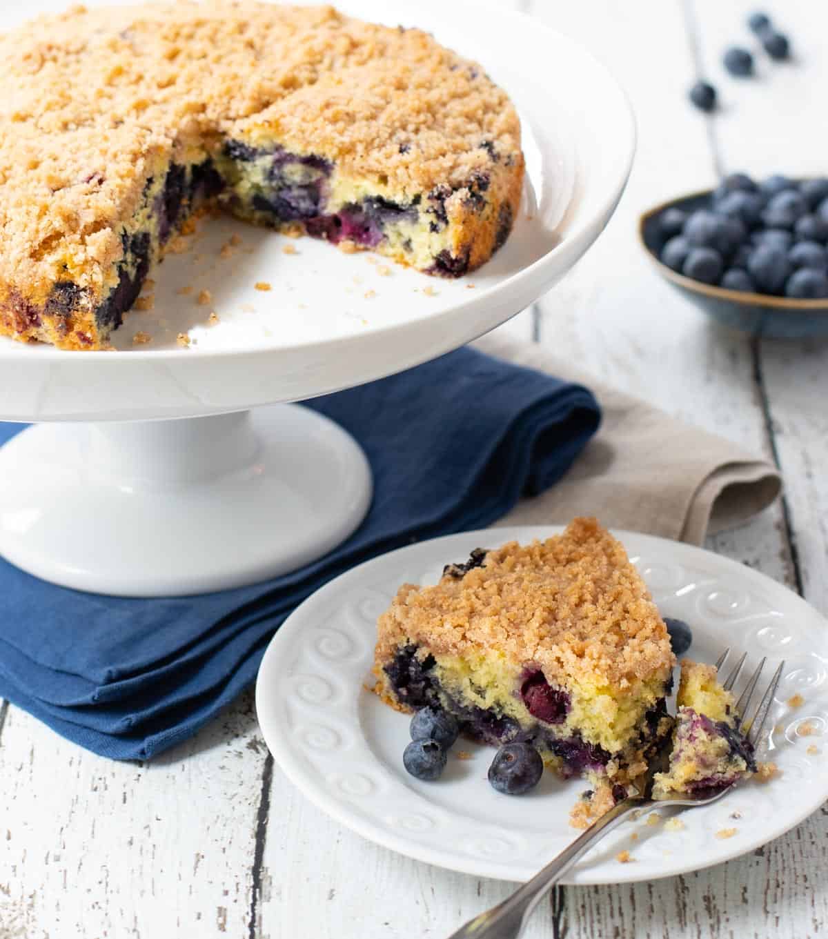 Blueberry Cake on cakestand with cake slice