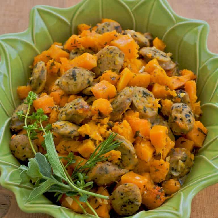 roasted chicken sausage and butternut squash in a green baking dish