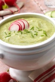 Chilled cucumber leek vichyssoise soup garnished with sliced radishes