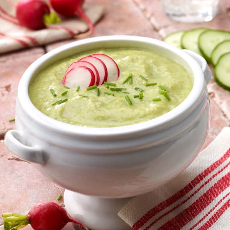 Chilled cucumber leek vichyssoise soup garnished with sliced radishes