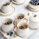White pots de creme filled with Frozen Lemon Velvet, topped with fresh blueberries.