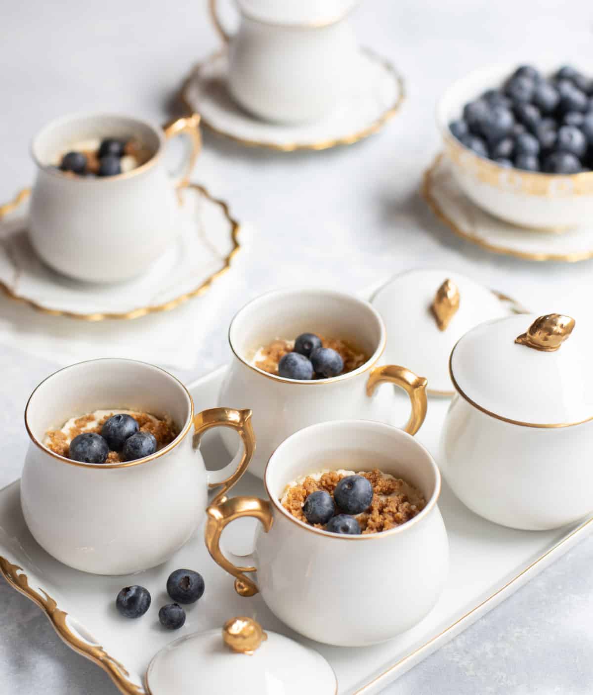 White pots de creme filled with Frozen Lemon Velvet, topped with fresh blueberries