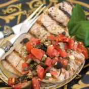 black and gold plate with Grilled Tuna with Puttanesca Sauce