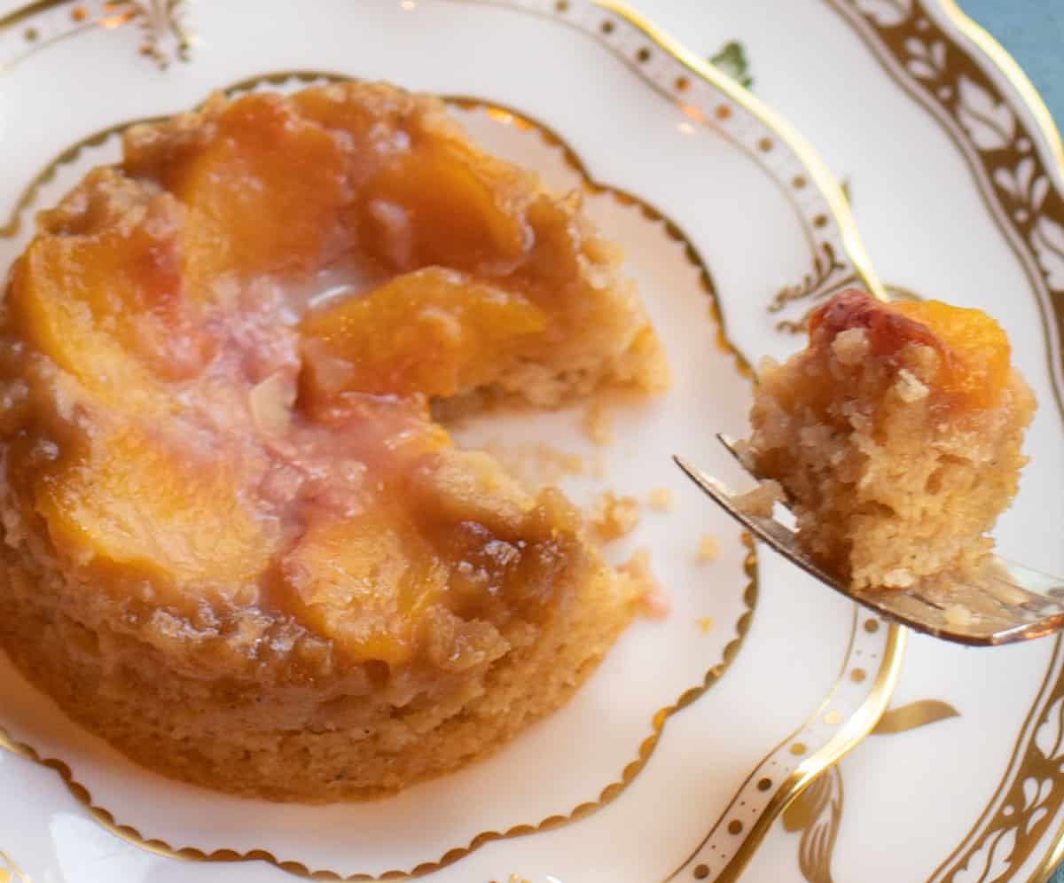 individual upside down peach cake with bite on a fork