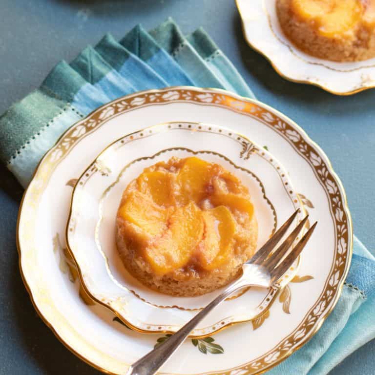 Individual upside down peach cake on a dessert plate