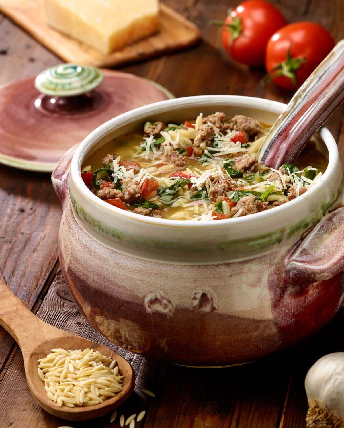 red and white soup turreen filled with Italian Sausage, Spinach and Orzo Soup