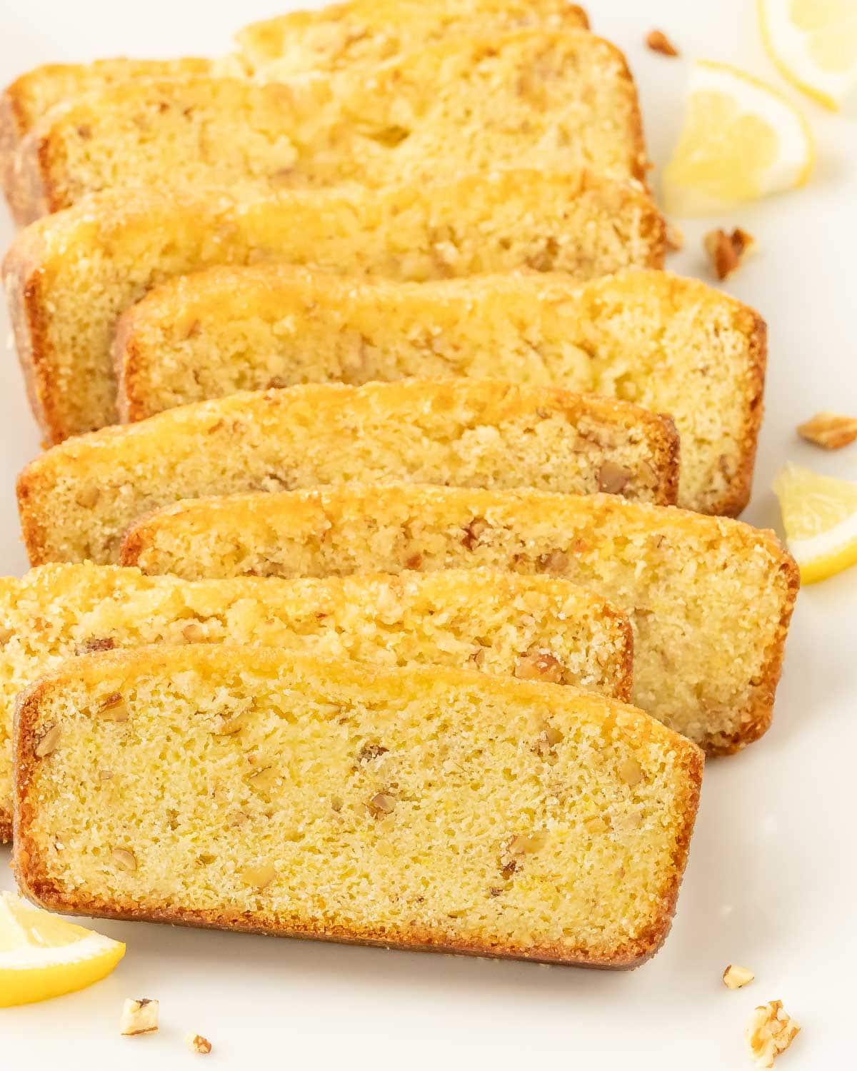 Eight slices of lemon bread, arranged overlapping on a white background.