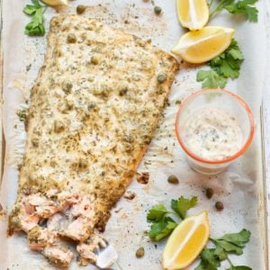 Salmon filet with lemon caper sauce on top and on the side