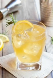 lemon ginger bourbon cocktail over ice in a glass, garnished with a lemon slice
