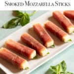 Retangular white platter filled with Prosciutto-Wrapped Smoked Mozzarella Sticks