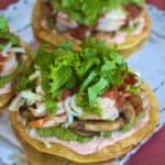 Sauteed shrimp and vegetables layered atop crispy corn tortillas with shredded cheese and lettuce
