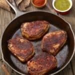 overhead of 4 Spicy Pork Chops in a cast iron skillet