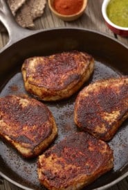 overhead of 4 Spicy Pork Chops in a cast iron skillet
