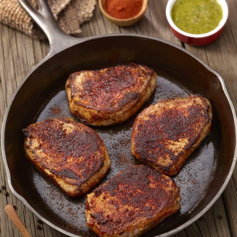 overhead of 4 Spicy Pork Chops in a cast iron skillet