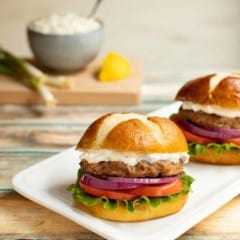 White platter with two Sundried Tomato Turkey Burgers and Lemon-Green Onion Sauce