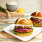 white platter with two Sundried Tomato Turkey Burgers with Lemon-Green Onion Sauce