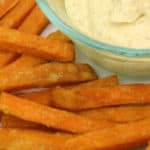 single portion of sweet potato fries with garlic sauce on the side.