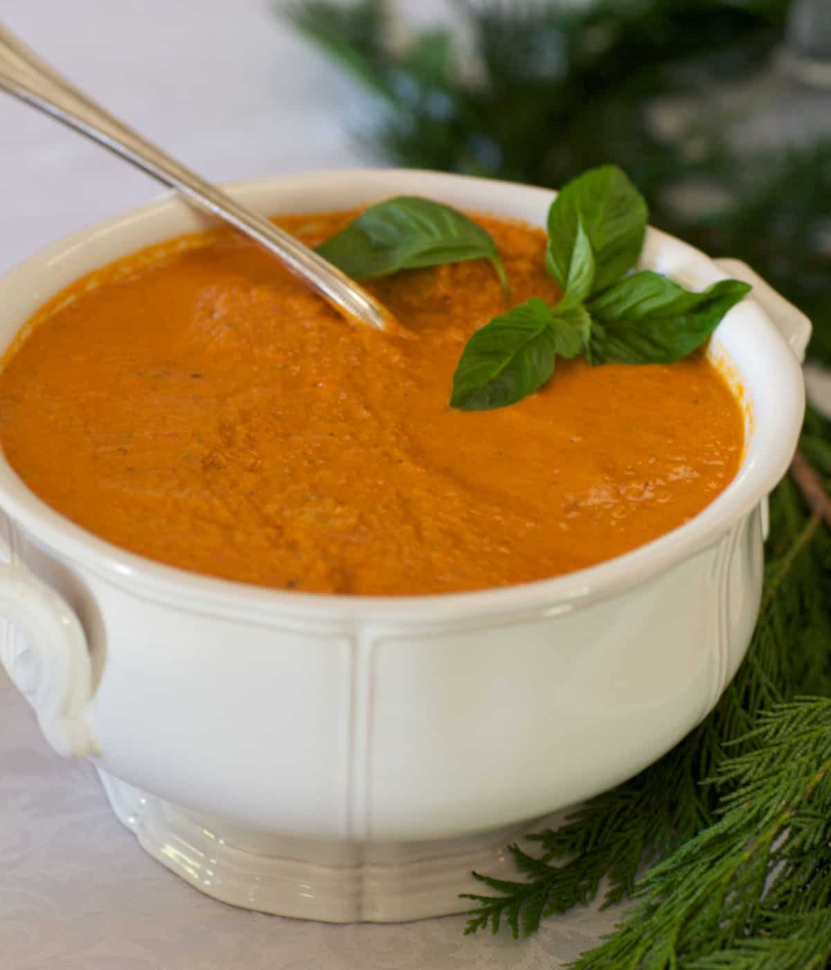 White soup tureen filled with Tomato Basil Bisque