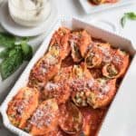 overhead of casserole dish filled with shells stuffed with ground turkey and vegetables and topped with marinara sauce.