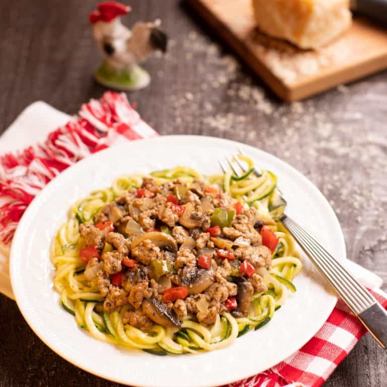 Seasoned ground pork sauce atop zucchini noodles on a plate