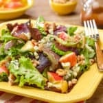 Square plate showing a generous portion of Mixed Green Salad with Apples, Walnuts and Stilton Cheese