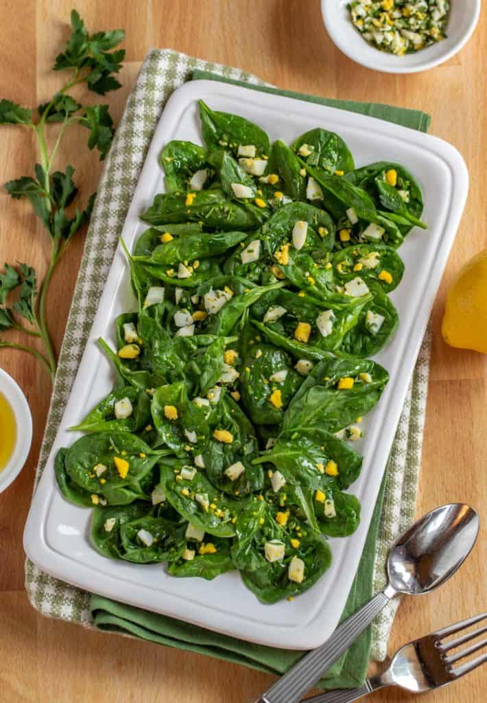 White square platter showing Baby Spinach Salad with Lemon Dijon Dressing