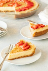 Two slices of Baked Cheesecake with the rest of the cake in the background