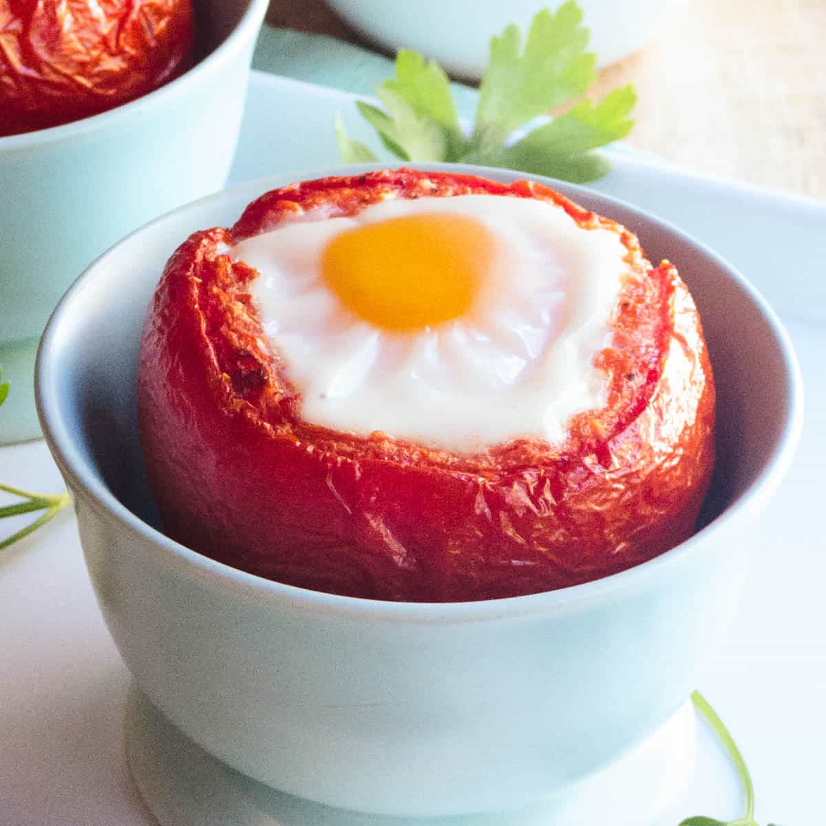Blue bowl filled with Baked Egg in Tomato