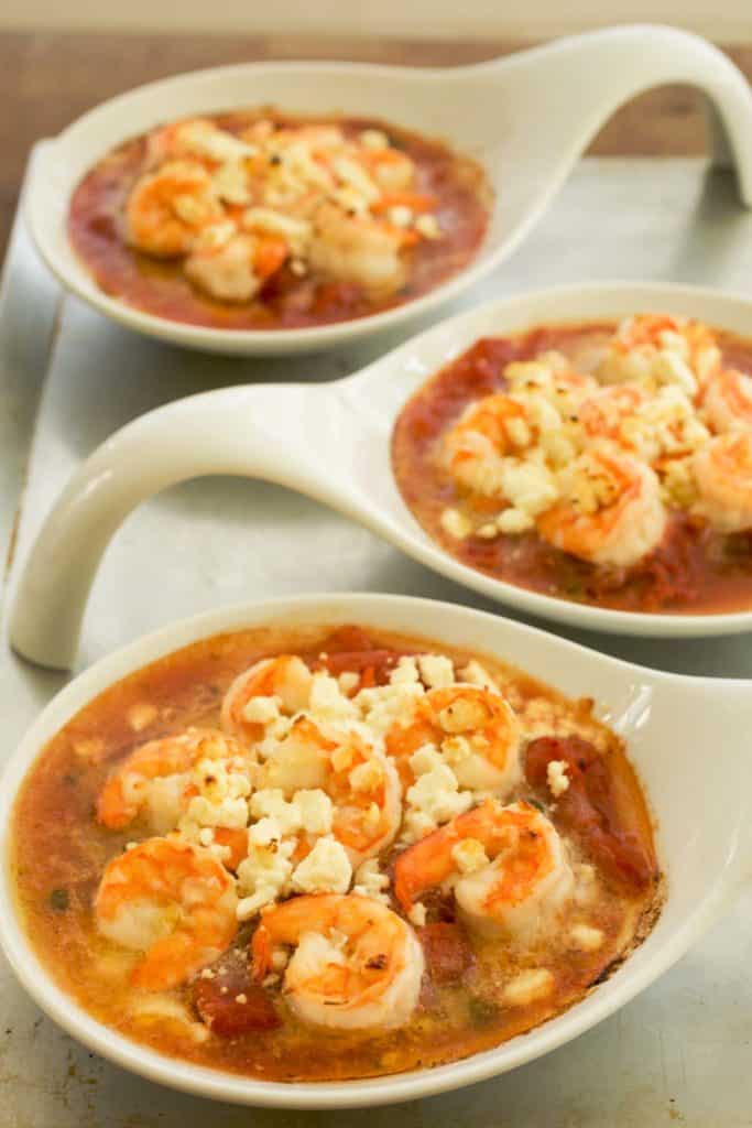 Individual white baking dishes filled with Baked Shrimp with Tomatoes, Feta and Capers