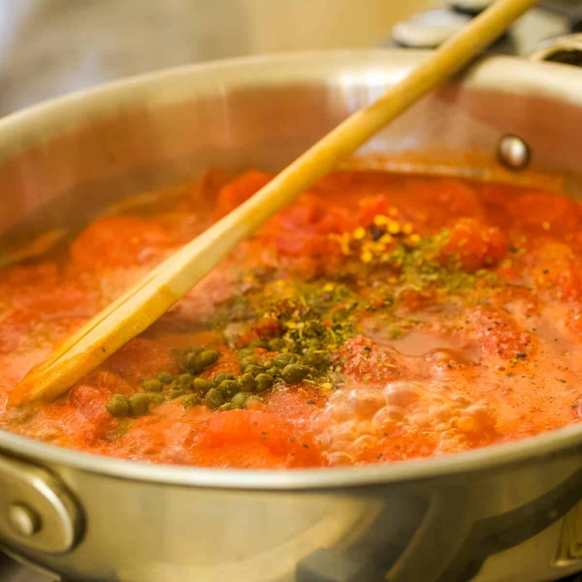 large saucepan holding tomato caper sauce.