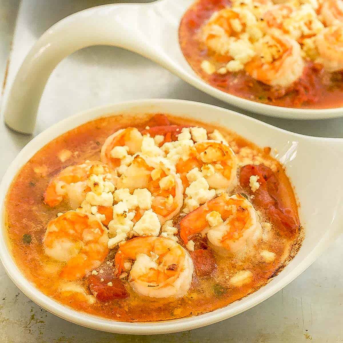 2 white small baking dishes each holding 1 portion of Baked Shrimp with Tomatoes and Feta.