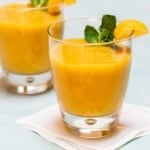close up of 2 glasses holding banana mango smoothies