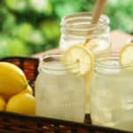 wooden tray holding 2 individual portions of Basil Lemonade with more in a large jar.
