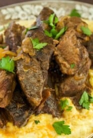 Cooked Beef Short Ribs sitting atop Creamy Parmesan Polenta