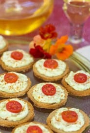 Platter filled with Benedictine Cheese Canapes and wine in the background