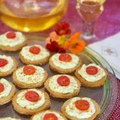 Platter filled with Benedictine Cheese Canapes and wine in the background