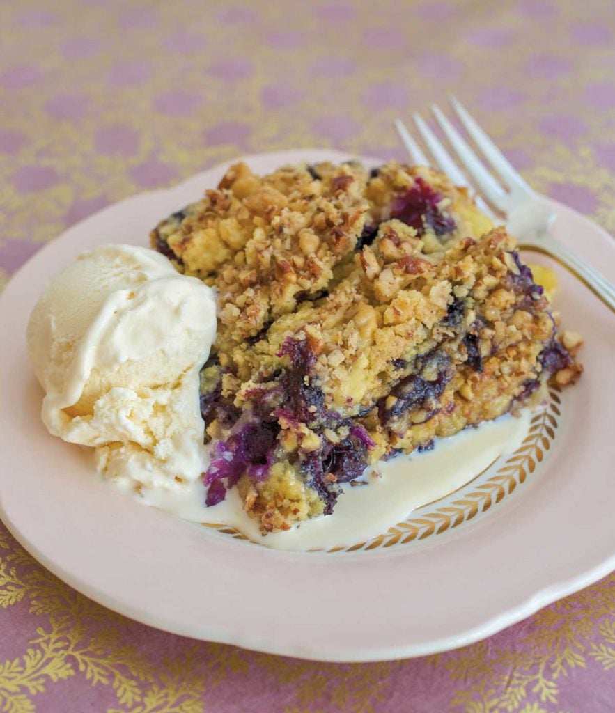 White plate showing a slice of Berry Cobbler Recipe, with a scoop of ice cream