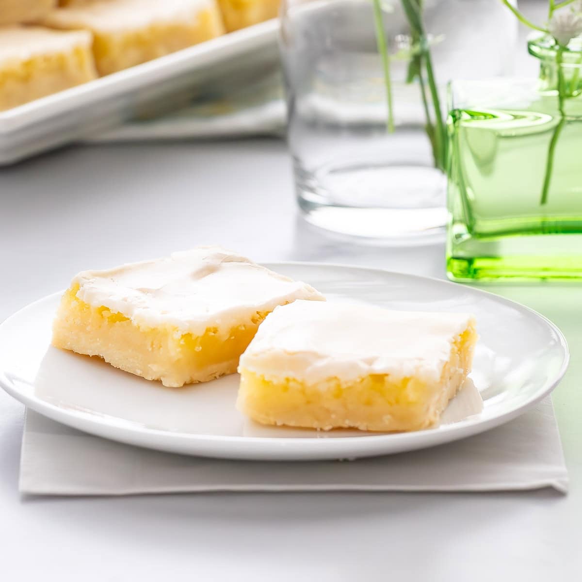 close up of a small plate holding 2 Homemade Lemon Bars