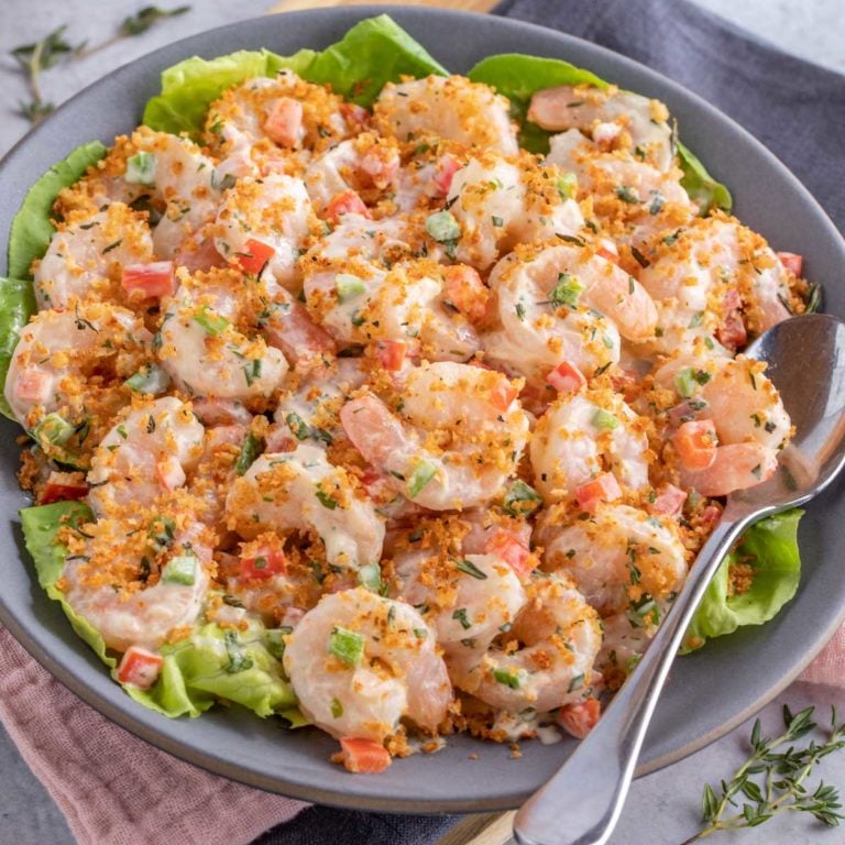 blue plate showing Shrimp Salad with Lime Herb Dressing; a serving spoon on the side