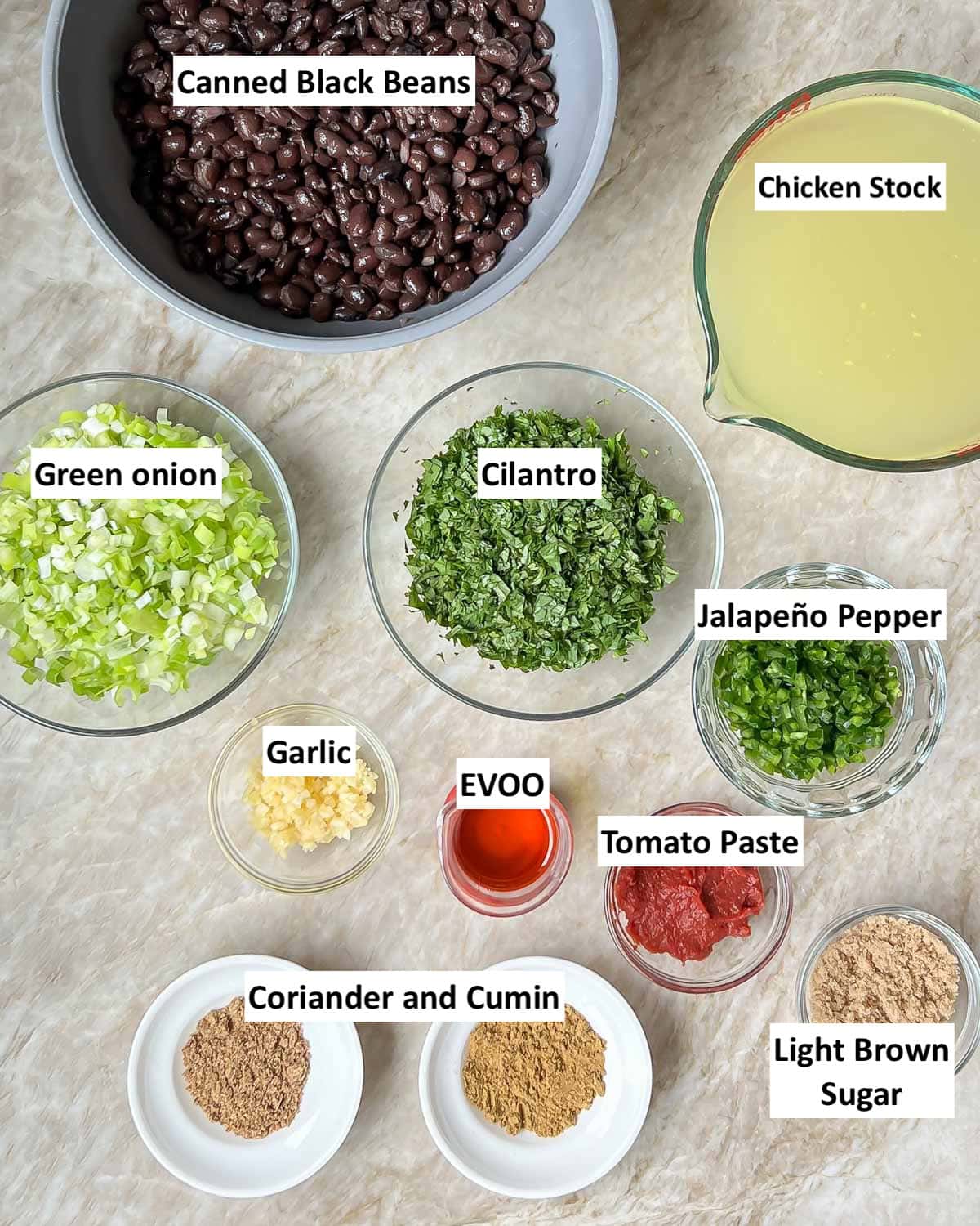 all of the black bean soup ingredients in individual bowls, each one labeled