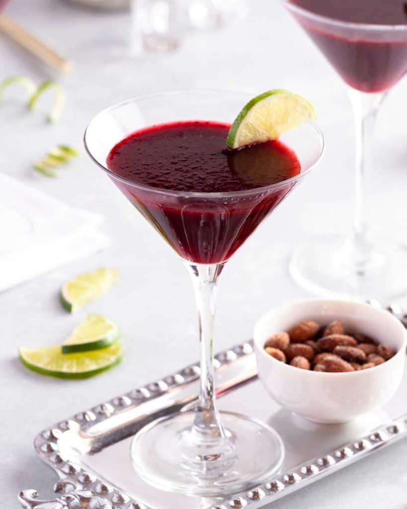 close up of a stemmed glass holding a Lime Blackberry Martini