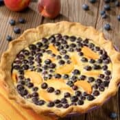 Blueberry and Peach custard pie with fresh peaches and blueberries on the side