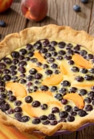 Blueberry and Peach custard pie with fresh peaches and blueberries on the side