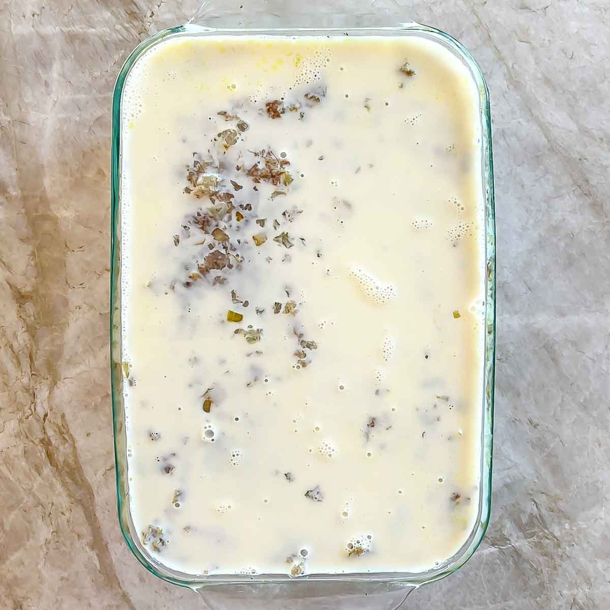 Creamy custard topping on top of bobotie before second round of baking